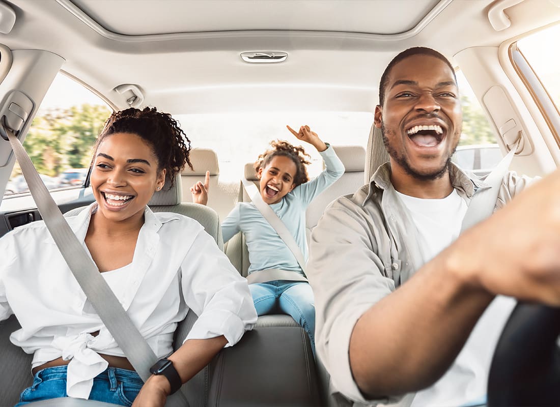 Personal Insurance - Happy Family of Three Singing and Having Fun While Riding in a Car
